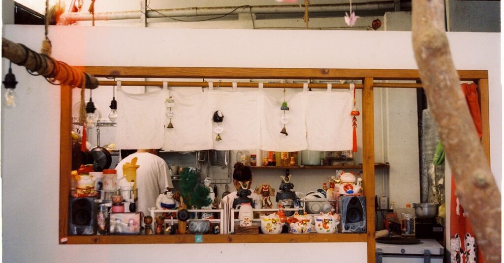 日本料理の料理長が丁寧に仕込みをする様子。繊細な手仕事と真剣な表情が印象的。
