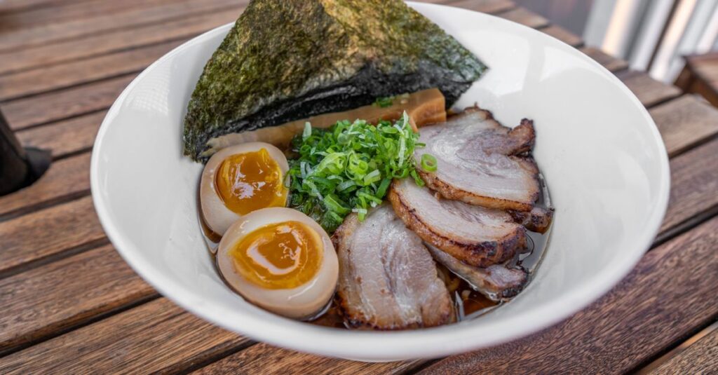 黄金色の出汁と美しく盛り付けられた和牛。見た目から上質さが伝わる構図。